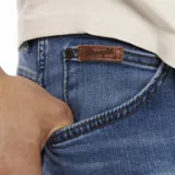 Pantalón de jean Wrangler de corte slim, color azul medio.