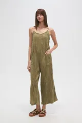 Mono de algodón color verde oliva, con textura plisada, escote en V y tirantes finos tipo lencero. Presenta bolsillos frontales y corte holgado.