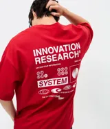 Remera de corte oversized color rojo, con cuello redondo y mangas cortas. Presenta un estampado gráfico en la espalda con el texto 'Innovation Research' y elementos de diseño técnico en color blanco.