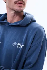 Buzo tipo canguro de felpa color azul con efecto lavado, capucha, bolsillo frontal tipo canguro y estampado gráfico pequeño en el pecho.