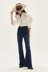 Jean de tiro alto, color azul oscuro, con calce ajustado hasta la rodilla y abertura ancha estilo oxford/flare.