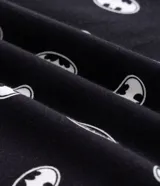 Pijama para hombre de dos piezas confeccionado en algodón, compuesto por una remera de manga corta a rayas horizontales con el logo de Batman en el pecho y un short negro con estampado integral de símbolos de Batman.