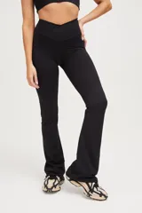 Calza larga negra de compresión media con cintura cruzada y corte acampanado.