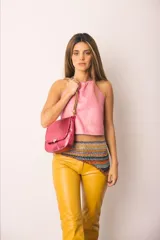 Pantalón de cuero color marrón con estampado abstracto, corte acampanado y abertura en el ruedo.