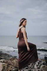 Top sin mangas color marrón con brillos, tejido en hilado brillante, con escote buche y lazo en el hombro.