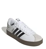 Championes Adidas VL Court 3.0 de estilo urbano, con capellada de cuero sintético blanco, icónicas tres tiras laterales en negro y puntera de gamuza en tono gris claro. Presenta una suela vulcanizada de color marrón oscuro y cierre mediante cordones.