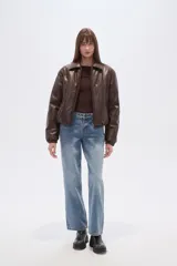 Campera estilo bomber de eco-cuero negra, con cuello camisero, cierre frontal y puños y cintura ajustados con elástico.