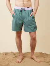 Short de baño verde con cintura lila y cordón de ajuste negro.