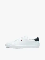 Zapatillas urbanas Tommy Hilfiger de corte bajo, color blanco con detalle azul en el talón. Tienen diseño con cordones, suela de goma blanca y pequeño logo bordado en el lateral.