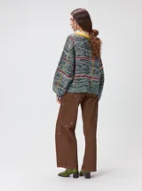 Sweater de punto grueso con cuello redondo, diseño de calce holgado y mangas amplias. Presenta un estampado geométrico de cuadros en tonos azulados con un gráfico central en color naranja y detalles bordados.