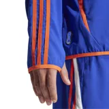 Campera Adidas F50 Woven color azul con detalles en naranja y blanco. Cuenta con cierre frontal, bolsillos con cremallera e inscripción F50 en el hombro y la espalda.
