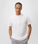 Remera masculina Marfinno de corte slim, confeccionada en tejido de piqué con textura. Presenta cuello redondo estilo Henley con abertura delantera de tres botones y mangas cortas.