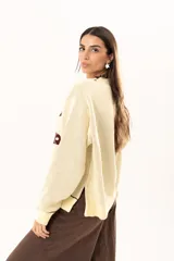 Buzo tejido de punto en color manteca, con diseño frontal de dos sardinas en color bordó. Presenta detalles bordados a mano en los bordes de las figuras y terminaciones con galón picot en cuello, puños y ruedo. Posee un corte holgado y aberturas laterales en el bajo.