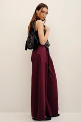 Pantalón bordó de corte ancho y relajado, con tiro alto y pretina con lazo ajustable.
