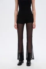 Pantalón de poliamida negro translúcido, de tiro bajo y ajuste ceñido al cuerpo con diseño acampanado en las pantorrillas.