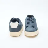 Zapatillas bajas de gamuza azul con cordones y suela de goma color crema.