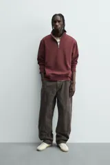 Sudadera roja de corte regular, con cuello alto y cierre frontal de cremallera. Manga larga y terminaciones en rib.