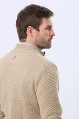 Buzo tejido de punto grueso en color azul marino, con cuello alto y cierre frontal parcial. Presenta detalles en gamuza en la zona del cierre y una textura en relieve en toda la prenda.