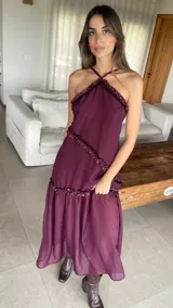 Vestido largo color bordó con escote halter y detalles de volados diagonales.