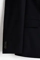 Blazer slim fit negro de botonadura sencilla, con solapas de muesca finas, bolsillos con solapa y abertura doble en la parte trasera.