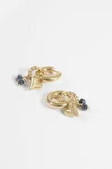 Aros argolla de acero quirúrgico plateado con dijes colgantes en forma de corazón y pequeñas cuentas de cristal oscuro.