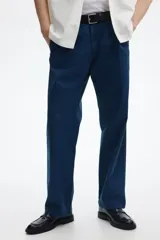 Pantalón de sarga de algodón en color azul marino, con corte relajado, cierre de cremallera y botón, bolsillos laterales al bies y bolsillos traseros insertados con botón.