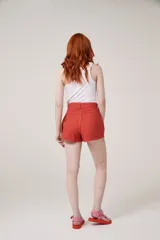 Short color rojo coral con lazo en la cintura y bolsillos delanteros.