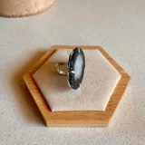 Anillo ajustable de alpaca con piedra de ágata natural en tono oscuro y centro claro, engarzada en metal plateado.