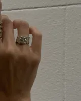 Anillo plateado con textura irregular y diseño rústico.