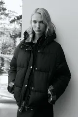 Campera puffer con capucha, cierre frontal y solapa con botones a presión. Cuenta con bolsillos laterales, elástico en puños y cordón de ajuste en capucha y bajo.