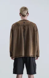 Buzo de cuello redondo con calce oversize y hombros caídos. Confeccionado en algodón gamuzado pesado con un proceso de lavado efecto óxido que genera un tono irregular. Presenta costuras expuestas a contratono y detalles de roturas en cuello, puños y ruedo, logrando una estética desgastada.
