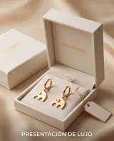 Caravanas de acero dorado tipo argolla con dije colgante en forma de elefante minimalista.