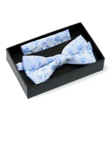 Conjunto de moña y pañuelo celeste con estampado floral azul, presentado en caja negra. El pañuelo mide 25x25 cm.