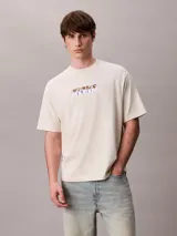 Remera Calvin Klein de color beige, corte relajado y manga corta, con cuello mock y gráfico abstracto de logo en bloque en el pecho.