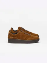 Championes Veja modelo V-90 Suede, confeccionados íntegramente en gamuja de color marrón coñac. Presentan puntera perforada, cordones tono sobre tono, suela de goma marrón y la clásica 'V' de la marca en el lateral con el mismo material y tono. Incluyen detalles de la marca grabados en el talón.