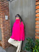 Sweater azul eléctrico de tejido de punto trenzado, cuello alto y corte oversize con aberturas laterales.