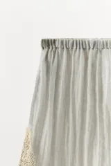Shorts de tiro medio y cintura elástica, confeccionados en hilatura con mezcla de viscosa. Presentan diseño fluido y detalles de encaje bordado a contraste en los laterales.