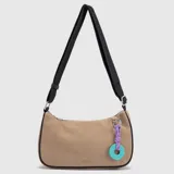 Cartera tipo baguette de gamuza en color tostado, con bordes reforzados en color negro. Cuenta con una correa larga ajustable de tela negra y un charm decorativo colgante compuesto por un cordón violeta y una pieza circular turquesa con logo grabado.