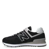 Championes urbanos New Balance modelo 574, color negro con detalles en gris y blanco. Confeccionados en una combinación de gamuza y malla, presentan el logo 'N' característico en los laterales, entresuela con tecnología ENCAP para mayor amortiguación y cierre mediante cordones.