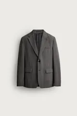 Blazer gris de corte regular fit con patrón a cuadros, confeccionada en tejido con mezcla de lana. Cuenta con cuello de solapa de muesca, cierre frontal de botonadura sencilla, bolsillos con solapa en la cadera, bolsillo de vivo en el pecho y aberturas en la espalda.