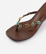 Sandalia de taco bloque Satinato, color marrón, estilo thong con tira de dedo decorada con apliques de piedras de resina y metales dorados.