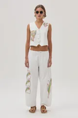 Pantalón barrel color crudo en gabardina 100% algodón, con bordados decorativos en ambas piernas.