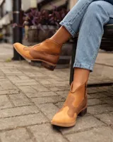 Botas cortas de estilo western confeccionadas en cuero, con puntera y talón texturizados con diseño de reptil y paneles laterales de gamuza. Presentan cierre lateral, tirador en la parte superior y taco bajo de madera.