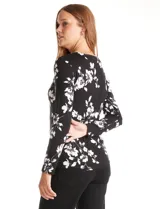 Remera de modal estampada con flores blancas sobre fondo negro, de manga larga y cuello redondo.