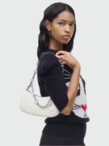 Cartera tipo shoulder bag Marc Jacobs, color blanco, con correa de cadena metálica plateada y detalles colgantes con estrellas.