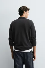 Polo de punto de corte regular fit, confeccionado en una mezcla de lana y cashmere. Presenta cuello solapa con cierre frontal de dos botones, manga larga y terminaciones en rib.