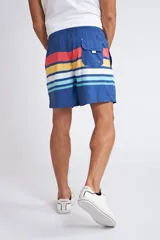 Short de baño con cintura elástica y cordón ajustable, confeccionado en tela ligera de secado rápido. Presenta un estampado botánico integral en tonos amarillos, blancos y azules, con dos bolsillos delanteros y uno posterior.