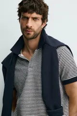 Chomba de punto con diseño de micro rayas horizontales en color azul marino y blanco, con cuello solapa y puños en contraste.