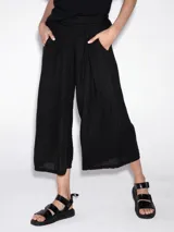 Pantalón negro tipo pescador, de corte amplio y tableado.