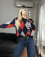 Sweater de tejido de punto con diseño de rombos en tonos verde oliva, verde oscuro y blanco. Presenta cuello redondo, mangas largas con puños acanalados y un corte holgado.